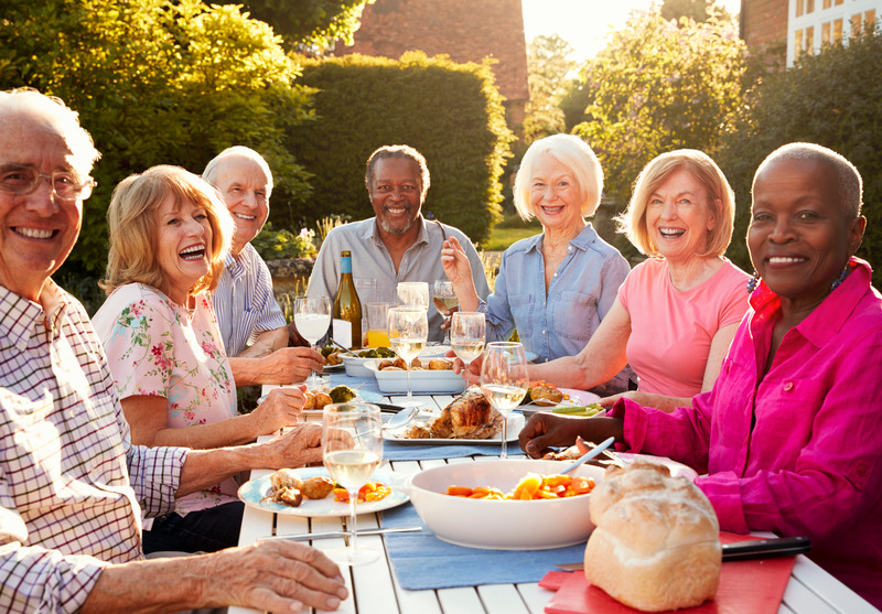 Portrait Of Senior Friends Enjoying Outdoor Dinner Party At Home